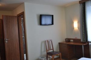 Sankt Andrä bei Frauenkirchen祖尔林德酒店的客房设有书桌和墙上的电视。