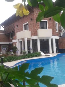 戈亚Costanera Goya Apart & Hotel的一座房子前面设有游泳池