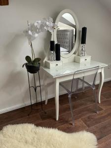 卡丹Apartmán的一张带镜子的白色书桌和一个花瓶