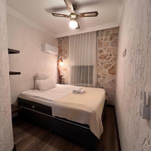 安塔利亚Villa Citronella Boutique Hotel的一间卧室配有一张带吊扇的床