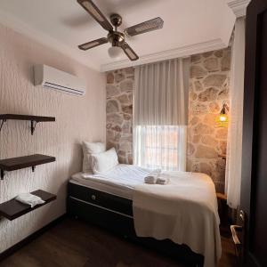 安塔利亚Villa Citronella Boutique Hotel的一间卧室配有一张带吊扇的床
