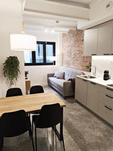 略夫雷加特河畔奥斯皮塔莱特ARIQUS Fira Apartments的厨房以及带桌椅的起居室。