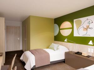 盖雷ibis Styles Guéret的一间卧室设有一张床和绿色的墙壁