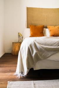 洛斯卡尼奥斯德梅卡La Posada de Trafalgar的一间卧室配有带橙色枕头的床