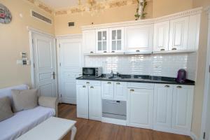 伊斯坦布尔IQ Hotel Galatasaray的白色的厨房配有白色的橱柜和沙发