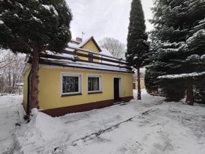 佩霍维采Zielony Zakątek的一座黄色的房子,地面上积雪