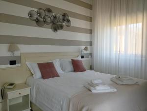 斯特雷萨拉丰塔纳酒店的卧室配有白色床和毛巾