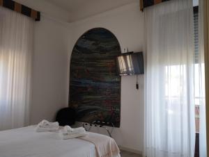 斯特雷萨拉丰塔纳酒店的卧室配有一张床,墙上挂有绘画作品