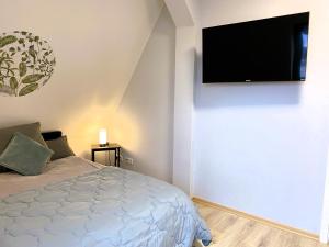 比勒费尔德City Appartement的卧室配有一张床和壁挂式平面电视。