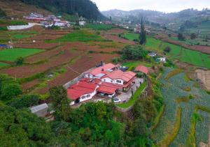 乌提Silent Valley Farm Resort Ooty by VOYE HOMES的山坡上一座红色屋顶的房子