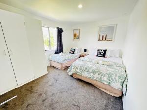 奥克兰Enjoy your stay Auckland的一间卧室设有两张床和窗户。