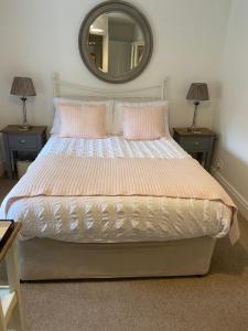 科尔内Rye Flatt Bed and Breakfast的一间卧室配有一张带两盏灯和镜子的床