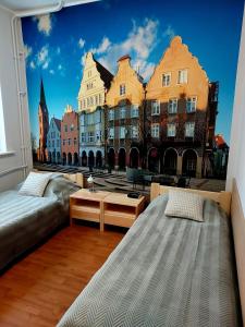 奥尔什丁Szkolne Schronisko Mlodziezowe w Olsztynie的一间设有两张床的客房,并拥有城市壁画