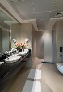 利雅德HDB Financial District的一间带三个盥洗盆和卫生间的浴室