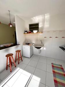 塞拉Kitnet na Vila de Manguinhos的一个带水槽和两个凳子的小厨房