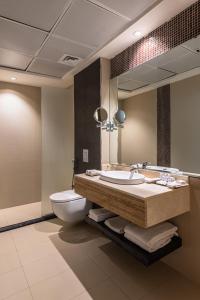 利雅德HDB Financial District的一间带水槽、卫生间和镜子的浴室