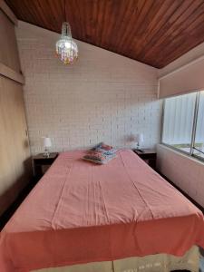 维纳德马Linda Casa 2D 1B的一间卧室配有一张大床和一个吊灯。