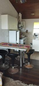 维纳德马Linda Casa 2D 1B的厨房配有桌子和凳子