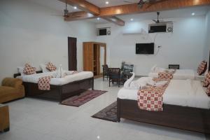 瑞诗凯诗Panambi Tapovan Resort的一间带两张床和电视的客厅
