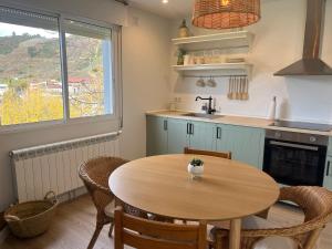 AbeledaCasa Catalina - Ribeira Sacra的厨房配有木桌、椅子和水槽