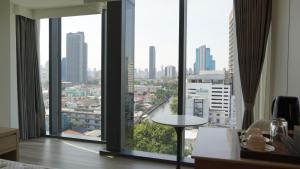 曼谷Shenzhen Tower Hotel Thonglor Sukhumvit的客房设有大窗户,享有城市美景。