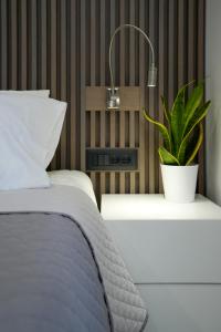 马斯蒂查里XeVa Studio的卧室配有一张床,在床头柜上种植植物