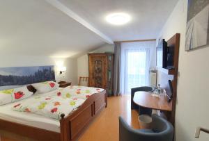 鲁波尔丁Hotel Garni Haus Alpine - Chiemgau Karte inkl的一间卧室配有一张床、一张书桌和一台电视