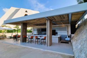 坎昆Wyndham Grand Cancun All Inclusive Resort & Villas的室外厨房,配有带凳子的酒吧