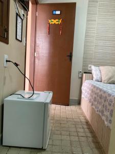 卡博迪圣阿戈斯蒂尼奥Pousada A Casa Portuguesa的一间房间,有一扇门,配有一张床和一把剪刀