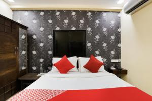 NarodaHotel Sunrise的一间卧室配有一张带红色枕头的大床