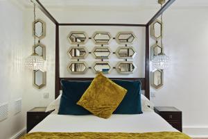 伦敦二十内文广场酒店的一间卧室配有一张带蓝色枕头的大床