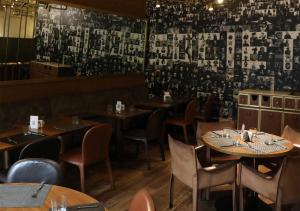 贝鲁特赛菲套房酒店的餐厅设有桌椅和一张带照片的墙壁