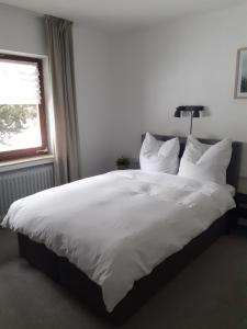 梅德巴赫Pension Orketal的白色的床、白色枕头和窗户
