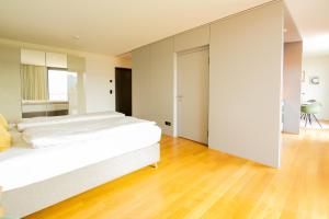 伯尔尼Senevita Residenz & Apartments Muri bei Bern的卧室配有一张白色的大床,铺有木地板