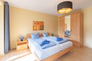 霍恩维舍多夫Strandhaus Fiete - Haus Poelblick - ABC247的一间卧室配有一张带蓝色毛巾的床