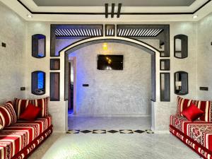 梅尔祖卡Merzouga DesertView Apartment的客厅设有2把红色椅子和门