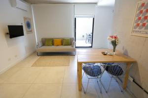 布宜诺斯艾利斯OWN Belgrano Studios & Suites的客厅配有桌子和沙发