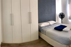 里约热内卢Loft Executivo - Ideal para família.的卧室配有白色橱柜和1张床。