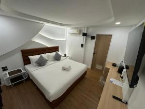武里南S1 City Hotel Buriram的一间卧室配有带白色床单和枕头的床。