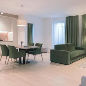 巴特拉德克斯堡Aparthotel Bad Radkersburg的客厅配有桌子和绿色椅子