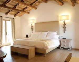 维琪奥港巴隆巴热亚大使大使酒店的卧室配有一张白色大床和木制天花板