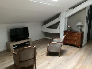 艾克斯莱班LA MANSARDE的客厅配有两把椅子和电视