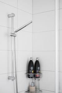 尼雪平Nyköping Villa: Serene & Stylish的浴室里设有淋浴,在架子上装有黑瓶