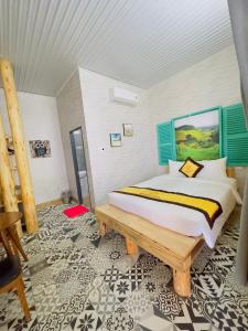潘郎Ninh Chu 2 Hotel的一间卧室设有一张大床和一张木凳