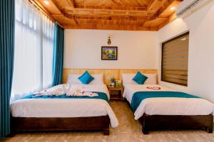 宁平Tam Coc Green Mountain Homestay的一间卧室设有两张床和木制天花板