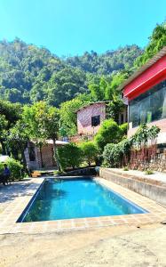 瑞诗凯诗Aum 108 Retreat - Rishikesh Mountains的房屋前的游泳池