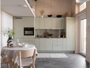 哥德堡Waterfront Cabins的厨房配有白色橱柜和桌子