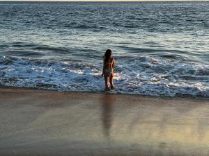 CoyucaCondominio Agave del Mar的站在海滩水面上的女人