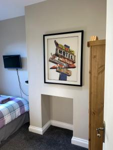 圣伦纳兹Single Room - Bed for the night - Close to Beach的墙上挂着酒店标志的照片的房间