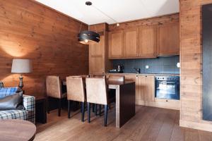 耶卢微斯里雅度假酒店的厨房配有木制橱柜和桌椅